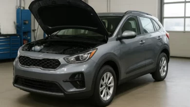 The image depicts a gray compact SUV with its hood raised, positioned in a workshop environment.