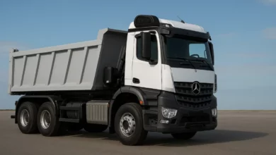 На зображенні зображено вантажівку з великим кузовом, яка стоїть на рівній поверхні.