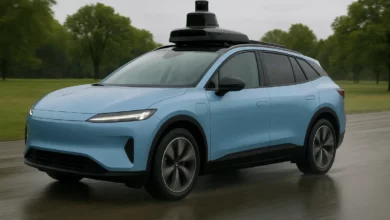 На зображенні представлені три різних транспортні засоби, що стоять у ряд: автобус з червоним дахом зліва, безпілотний автом…
