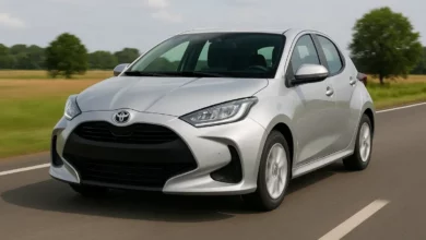 На зображенні видно компактний автомобіль, розташований по центру дороги, що рухається у напрямку камери.