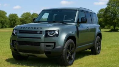 Зображено броньований автомобіль, розташований на відкритій місцевості з зеленими травами та деревами на фоні.
